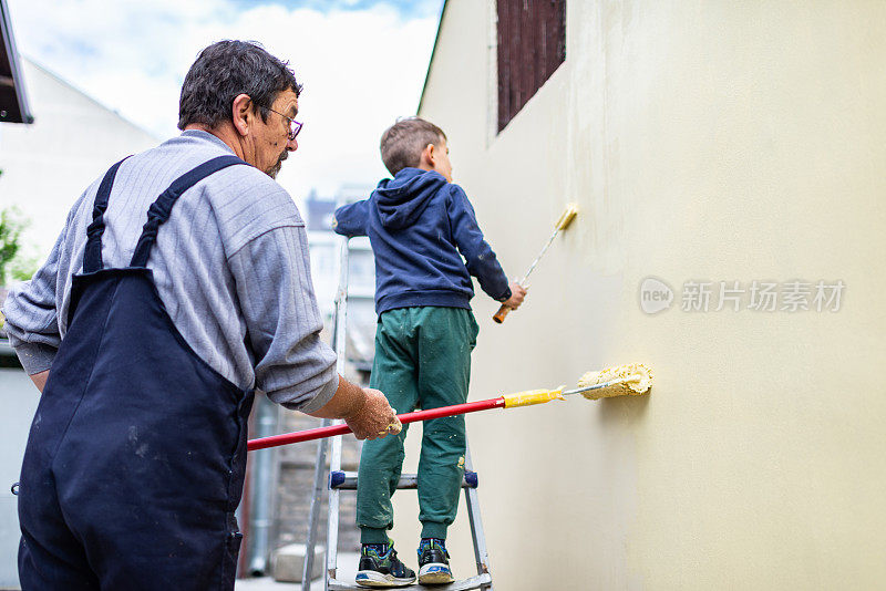 小男孩在帮他爷爷刷墙