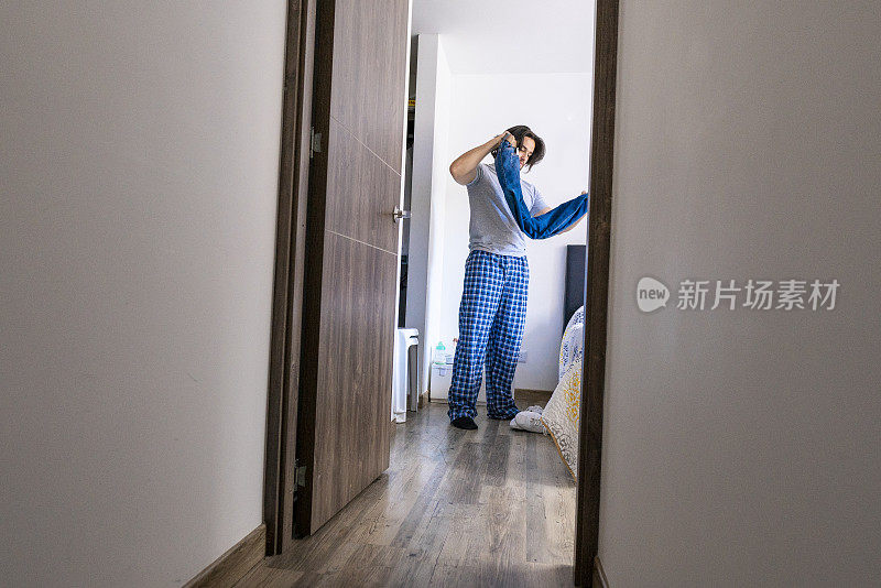 拉丁裔男子在房间里整理他的衣服