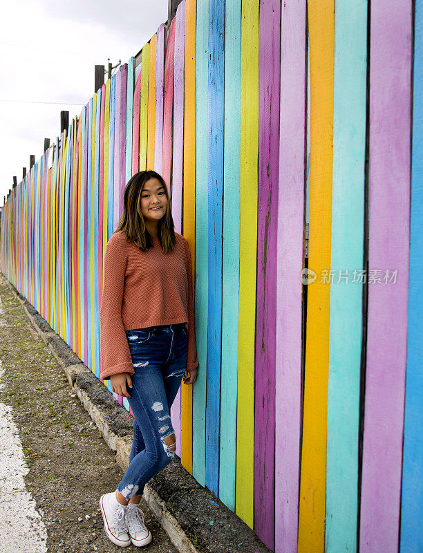 亚洲年轻的成年人对着充满活力的彩色墙壁