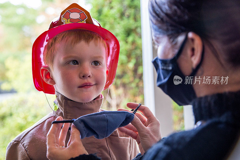 2019冠状病毒病大流行前夕，母亲给孩子戴上防护口罩