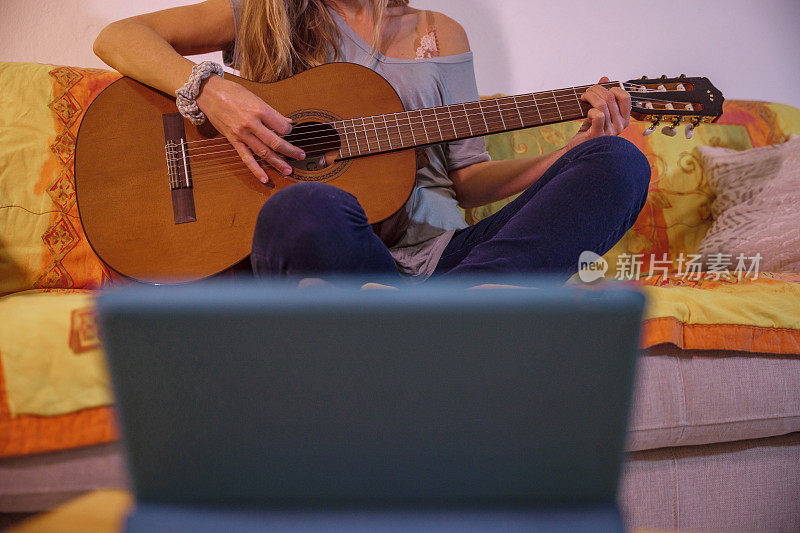 女子通过数字平板电脑在线学习吉他
