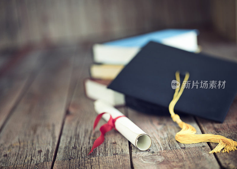 毕业帽和文凭概念上的一个木材背景