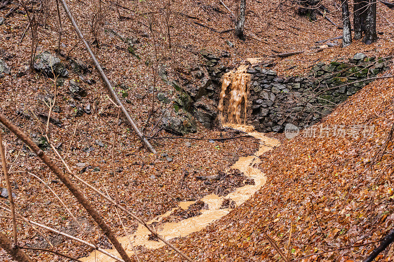 生态和可持续性。秋天脏瀑布在山上。顺着山坡流下的小河等待清理。