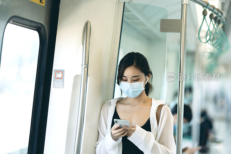 亚洲女性在乘坐地铁或火车时，会戴口罩、使用智能手机和耳机，并保持社交距离