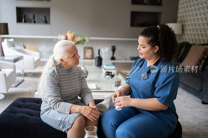 护士帮助老年妇女在家服药