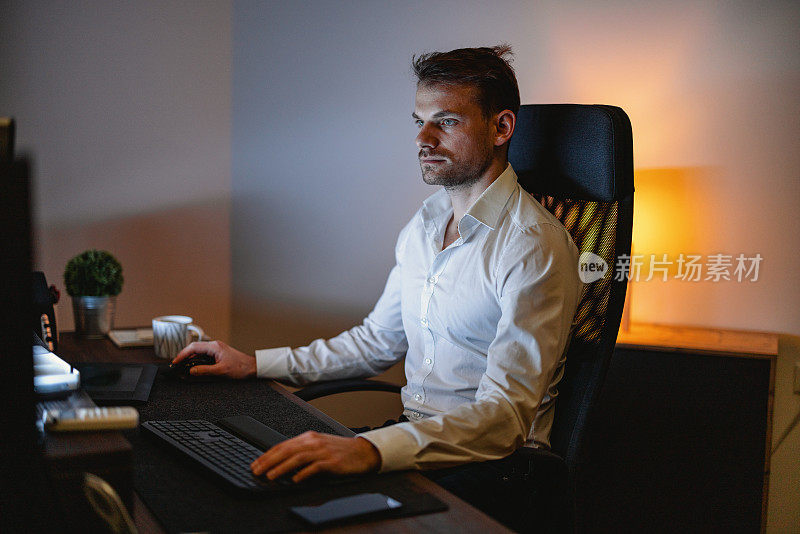 商人深夜在办公室用他的台式电脑