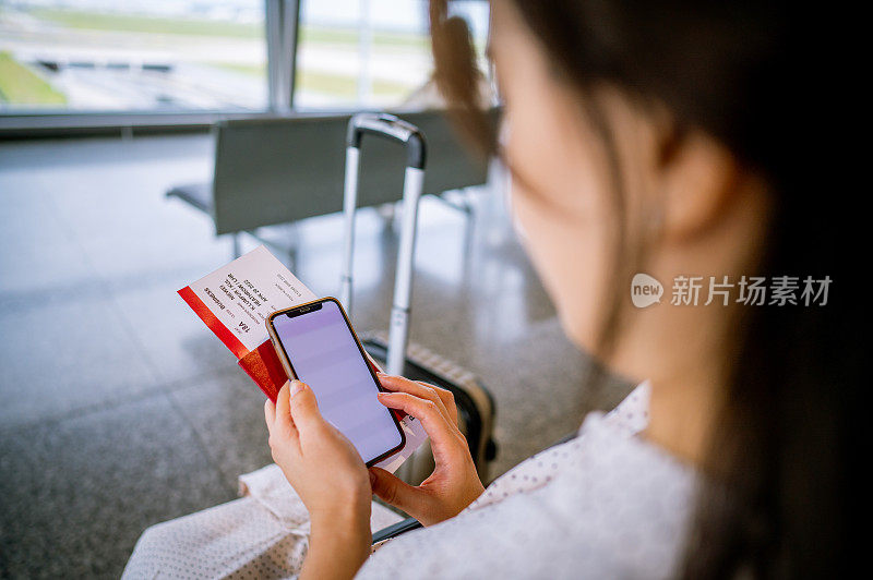 一位亚洲华裔女商人在机场等待她的航班。个人商务旅行理念。