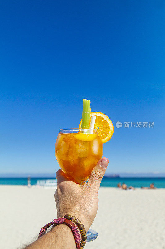 一名年轻的旅行男性在大西洋前享受他的假期，喝着鸡尾酒，在南海滩，迈阿密海滩，迈阿密，南佛罗里达，美国