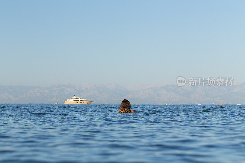 地中海的海景和一个远离海岸的年轻女子。