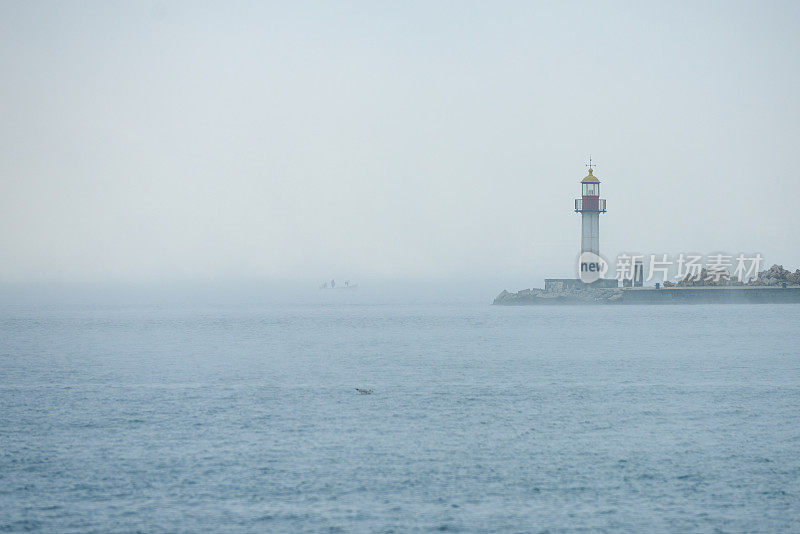 日出时分雾海中的灯塔