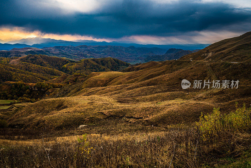 从俄罗斯厄尔布鲁斯地区的冈巴什山口，欣赏山脉山脊和山谷的壮丽日落