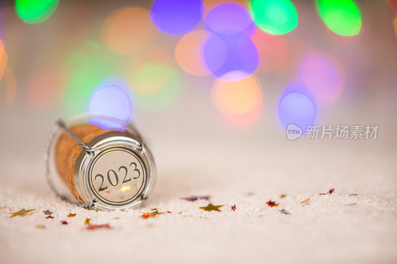用星星形状和雪上的软木塞祝你2023年新年快乐
