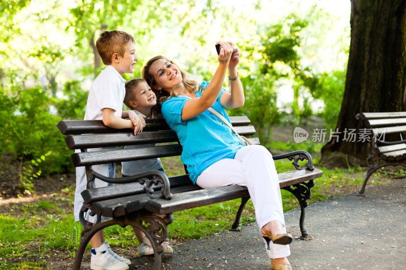 母亲和孩子们在公园里使用手机