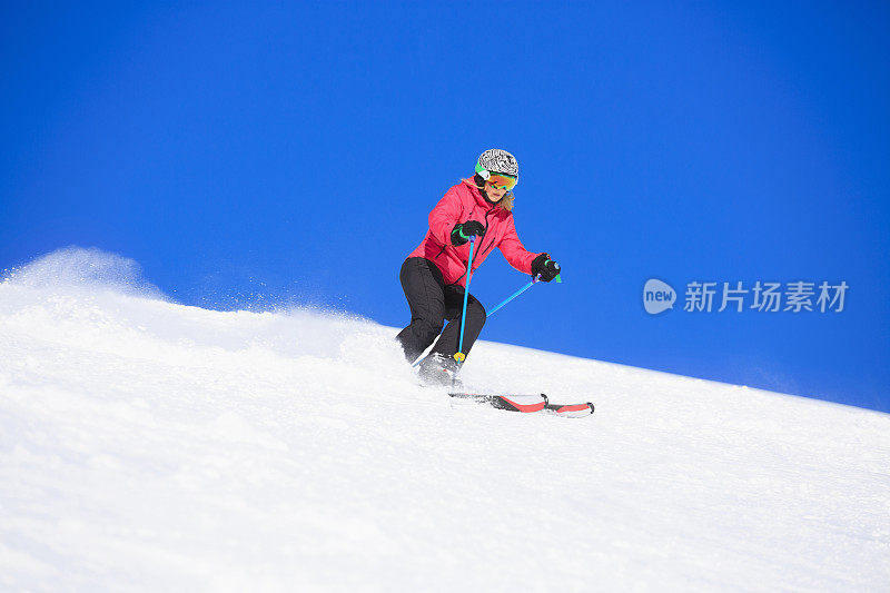 在阳光明媚的滑雪胜地滑雪的中年妇女滑雪