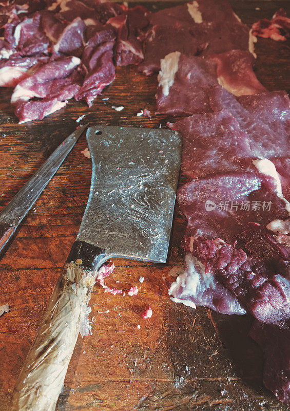 屠夫用工具把肉放在桌子上