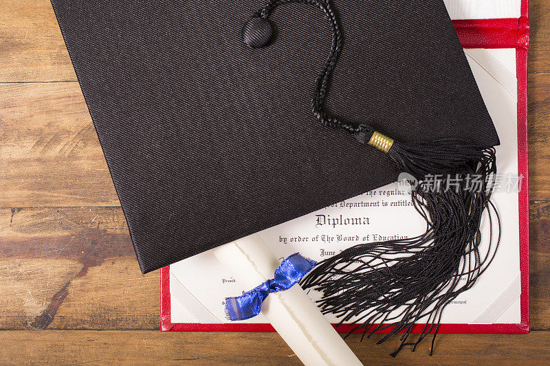 毕业!桌上放着学士学位帽、学士帽和流苏。教育。