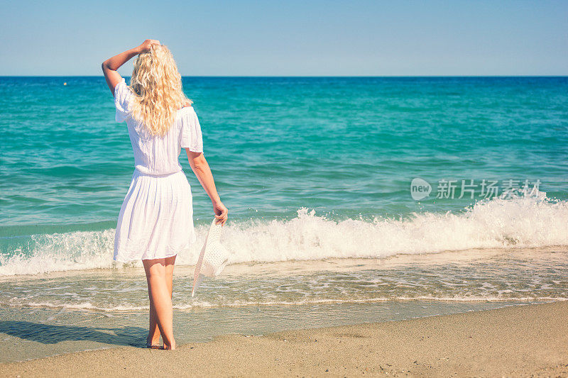 美丽的年轻女人在海滩上享受