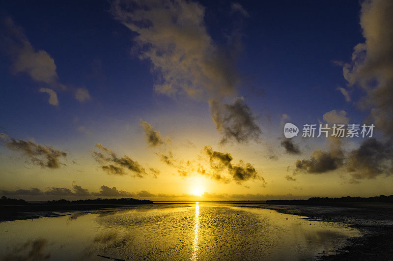 日出时海岸泻湖上戏剧性的天空反射