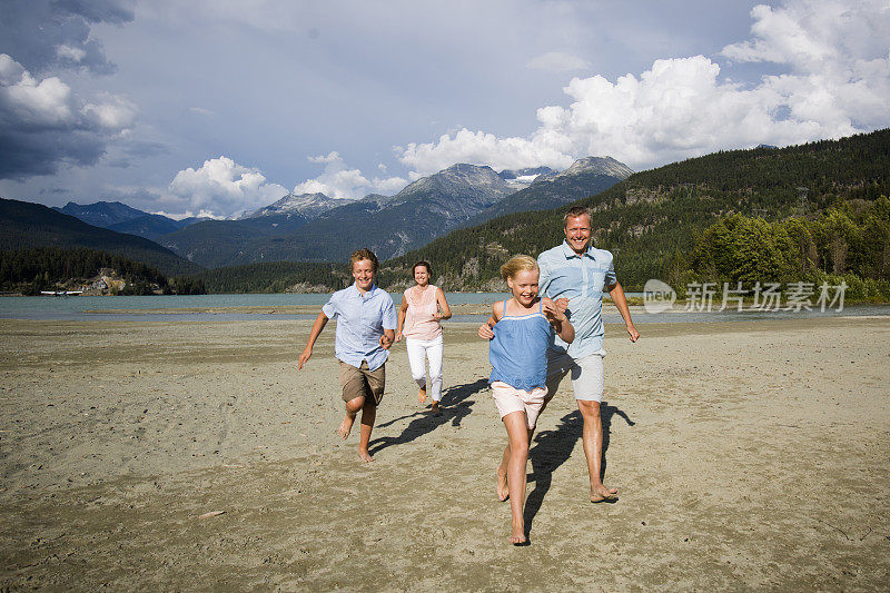 一家人在沙滩上玩，互相追逐。