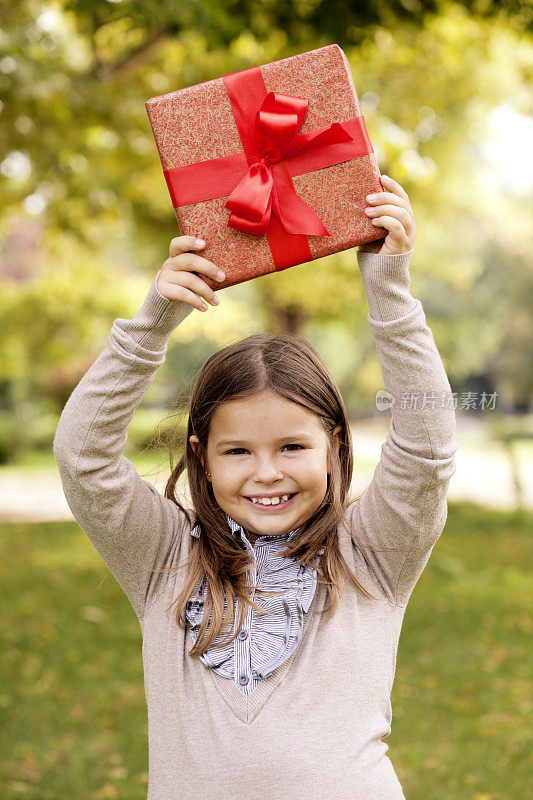 可爱的女孩拿着红色礼盒