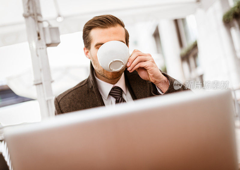 在cafè用笔记本电脑工作的商人