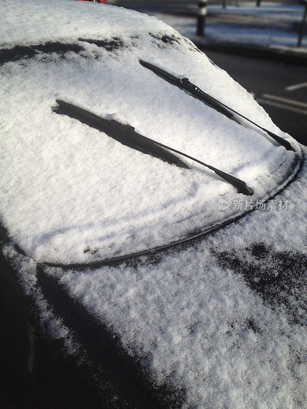 阳光下融化的雪覆盖着汽车