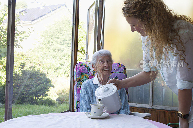为年长女性提供咖啡的看护