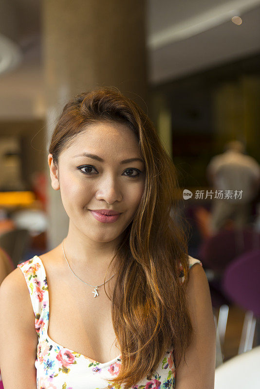 年轻亚洲女人在咖啡馆的肖像