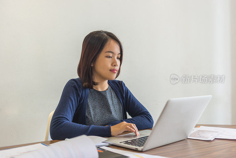 一位亚洲办公室女士盯着笔记本电脑屏幕的肖像