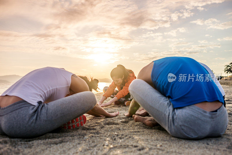 朋友们在海滩上做瑜伽