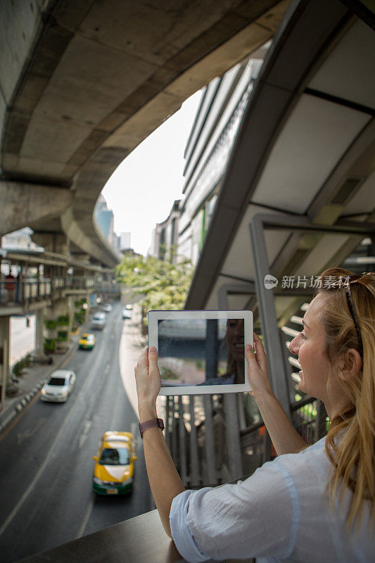 曼谷的一名女子用数码平板电脑拍照