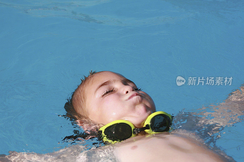 小男孩戴着护目镜游泳