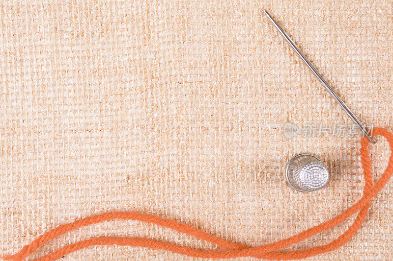 工艺背景:针和线缝进粗麻布。橙色