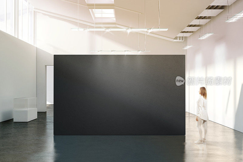 女人站在现代白色画廊附近的空白黑墙模型