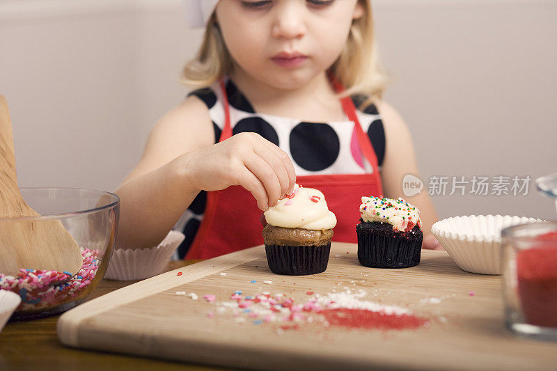 小女孩近距离装饰纸杯蛋糕