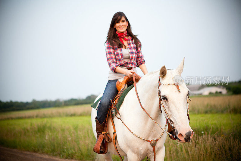 快乐，年轻的女牛仔在外面骑马