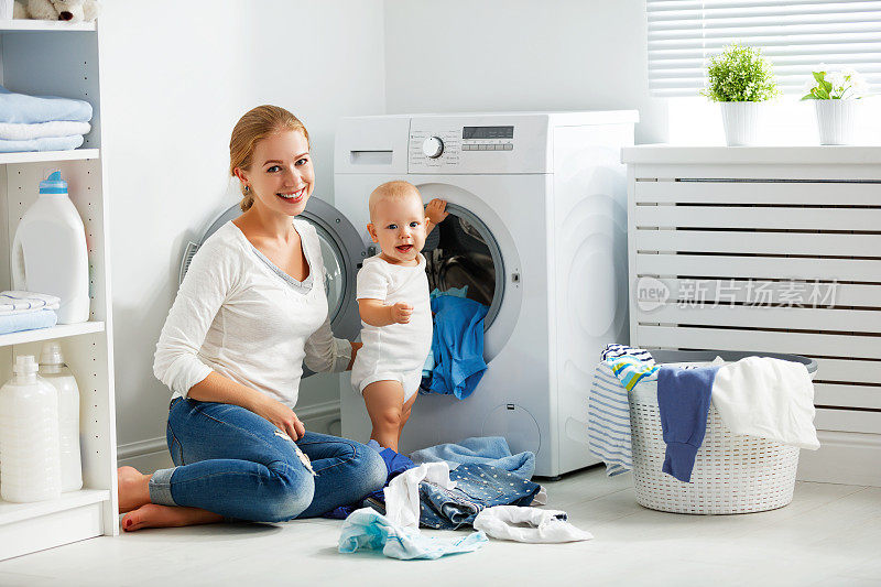 母亲家庭主妇与婴儿从事洗衣折叠衣服到洗衣机