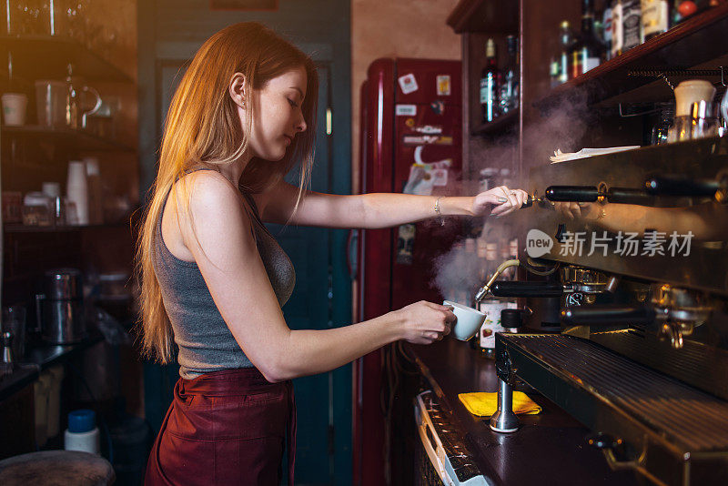 时尚的姜姑娘在咖啡馆用专业的咖啡机煮咖啡