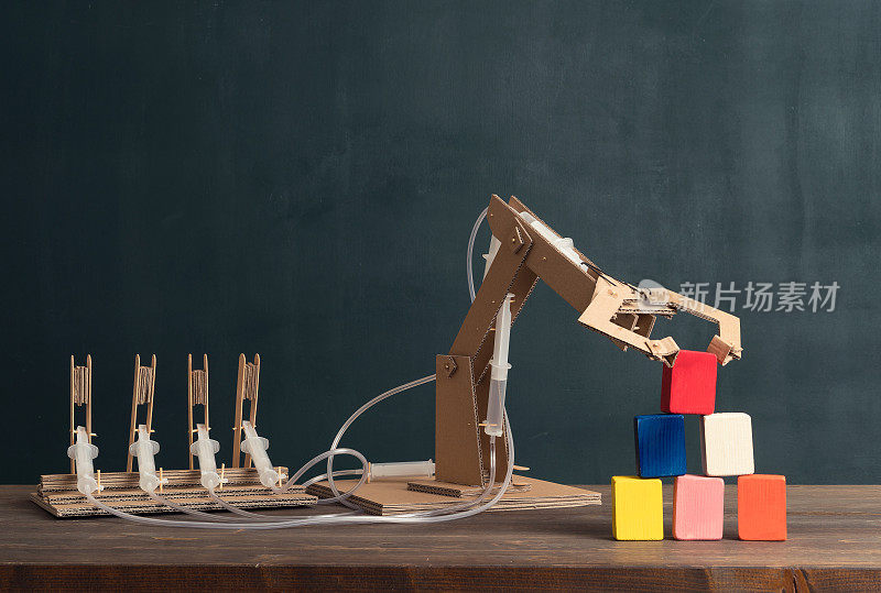 可爱的孩子发明了带有纸板的机器人手臂。