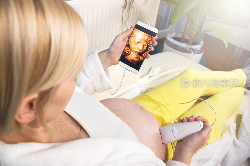 一个女人在家为她的宝宝做数字3D超声波