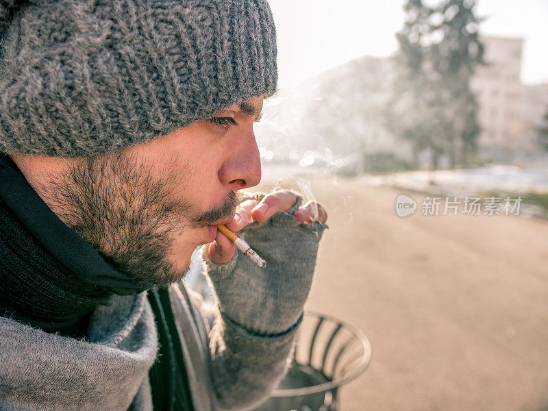 一个潮人在公园里吸烟的特写照片