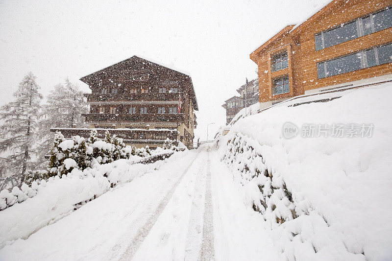 一场暴风雪中，一条被雪覆盖的道路蜿蜒穿过瑞士策马特滑雪场