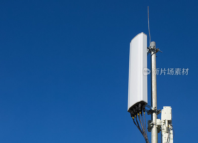 GSM、DCS、UMTS、LTE频段的面板天线和无线电单元作为基站通信设备的一部分，安装在屋顶上，蓝天为背景