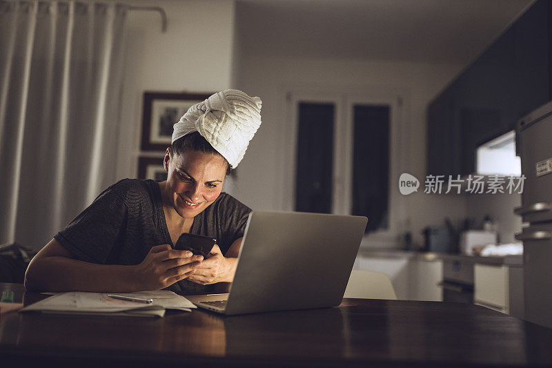 年轻女性在家里用笔记本电脑工作到很晚