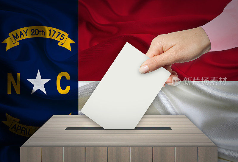 手与投票选票和盒子在旗帜，北卡罗莱纳