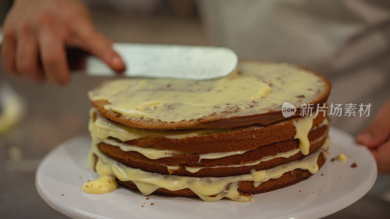 厨师把奶油涂在裸蛋糕上