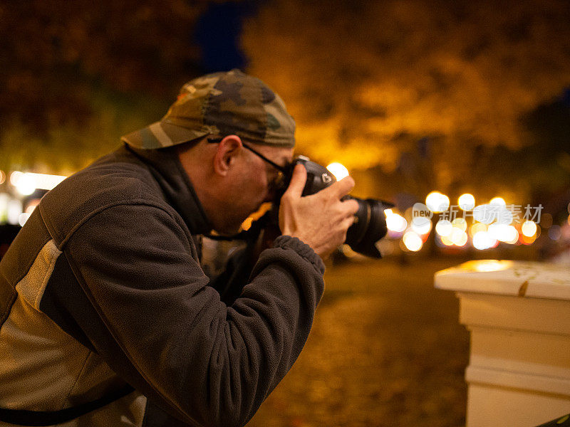 夜间城市男性街头摄影师拿着相机