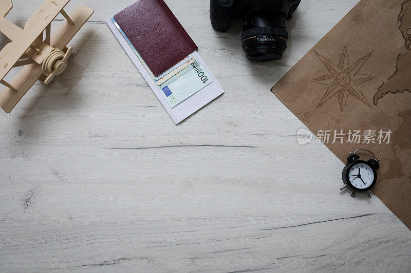 护照，世界地图和迷你飞机放在老式木桌上。旅行者的概念元素这个形象
