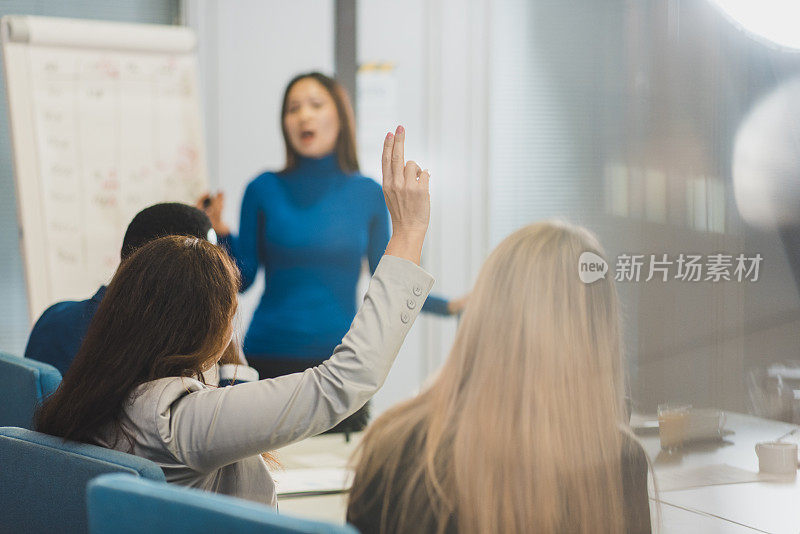 女商人在演讲中举手提问