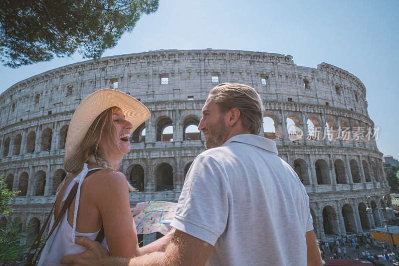 一对年轻夫妇在罗马斗兽场看旅游城市地图问路
